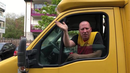 Parcel carrier Michael leans out of the window of his car.