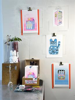 A booth with art prints by Lucky Cat Studio.