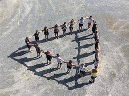 Impressions from the Muros Week with Martin Pfeifle. For four days, 20 students zigzagged through the Ruhr region. You can see the students hand in hand in a triangle formation.