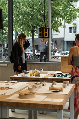 Impressions from the 2023 Summer Craft Show. Visitors view an exhibited work from the New Craft Object Design program.