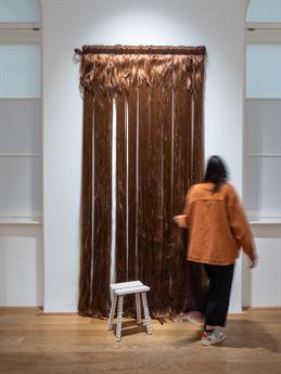 A photo from a project on display. You can see a floor-length curtain of brown hair.